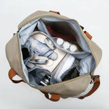 Open beige backpack with various items and a 'wet' label on a light gray background