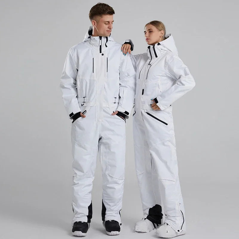 Two people wearing white ski suits on a gray background
