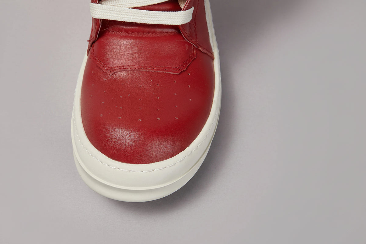 Red sneaker with white sole on a gray background