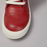 Red sneaker with white sole on a gray background