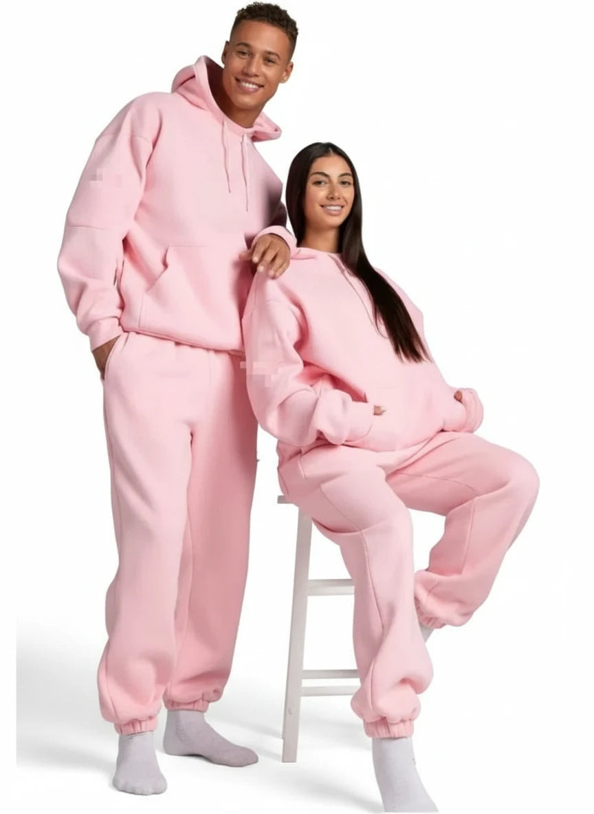 Two people wearing pink onesies on a white background