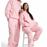 Two people wearing pink onesies on a white background