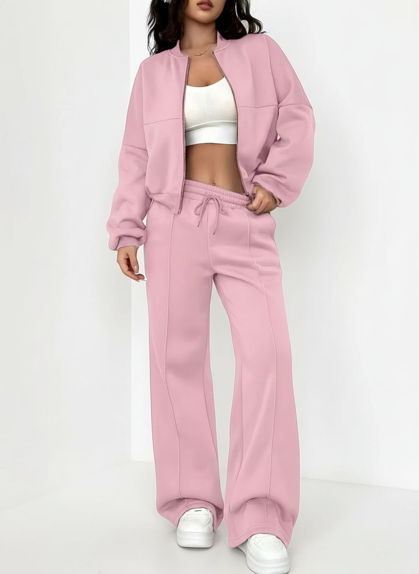 Person wearing a pink tracksuit with a white top on a white background