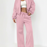 Person wearing a pink tracksuit with a white top on a white background