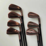Set of golf clubs with rose gold heads on a light gray background