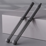 Two gray spring-loaded tools on a reflective surface with a neutral background