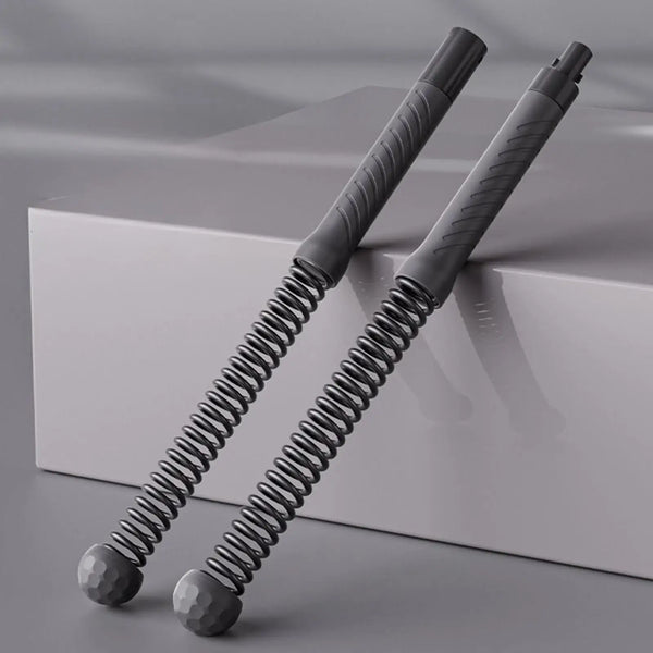 Two gray spring-loaded tools on a reflective surface with a neutral background