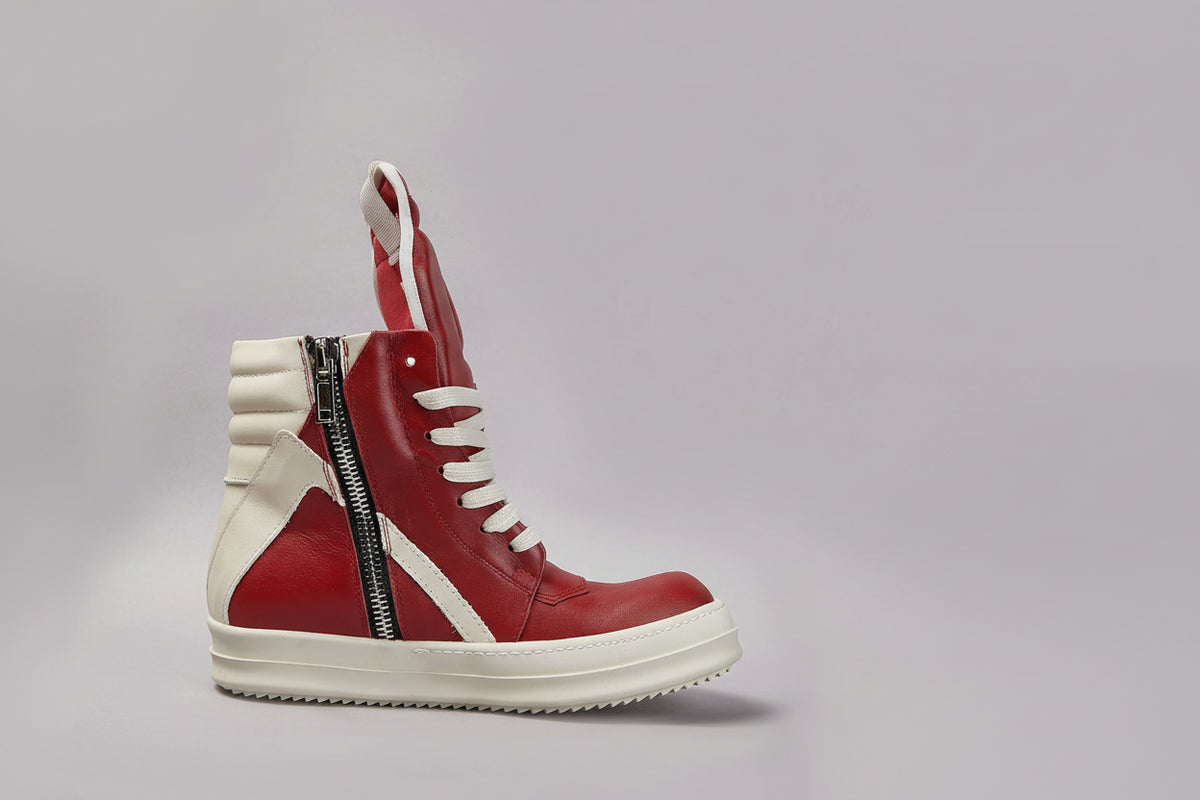 Red and white sneaker with a zipper on a gray background
