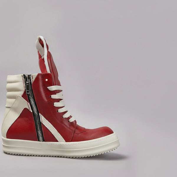 Red and white sneaker with a zipper on a gray background