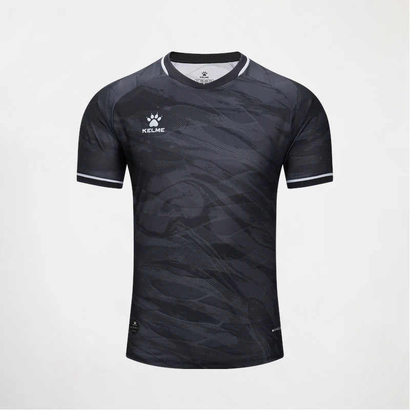 A short-sleeve athletic jersey by Kelse, featuring a dark gray and black abstract wave pattern, with white trim on the collar and sleeve cuffs, and a white Kelse logo on the left chest.