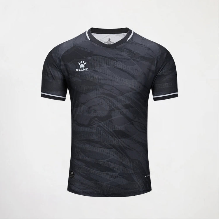 A short-sleeve athletic jersey by Kelse, featuring a dark gray and black abstract wave pattern, with white trim on the collar and sleeve cuffs, and a white Kelse logo on the left chest.