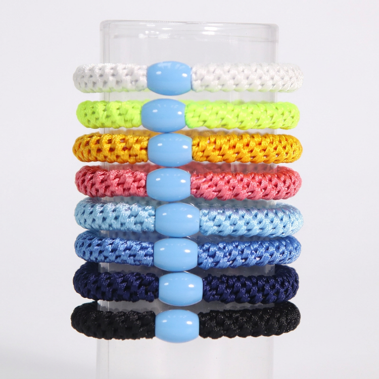 Eight colorful braided hair ties on white