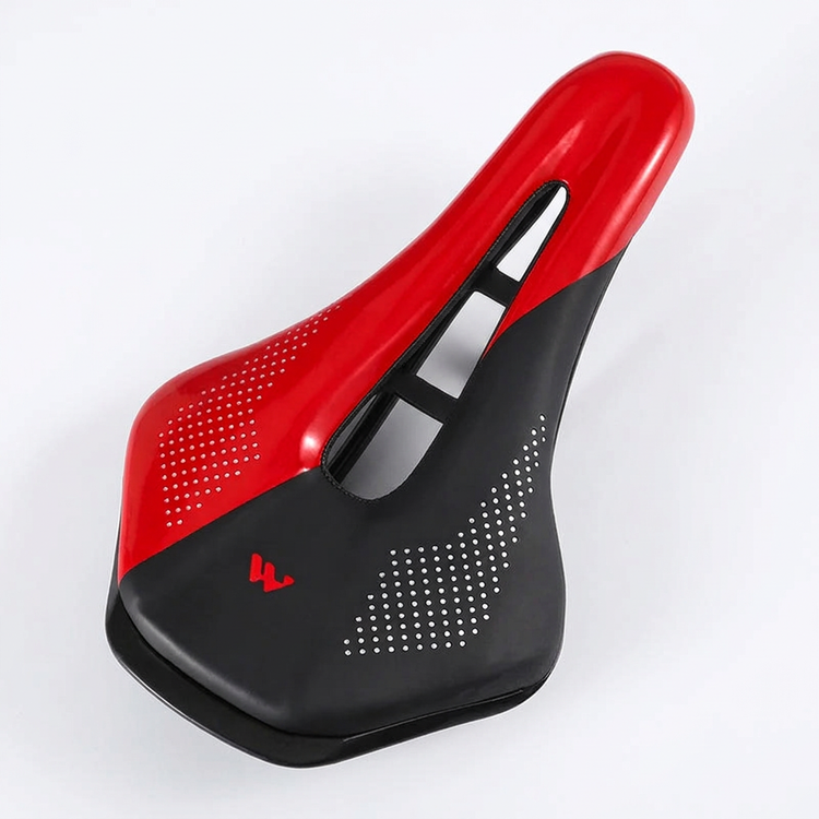 Red and black bicycle saddle with a central cutout on a white background
