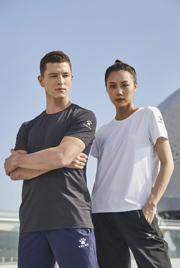 Two models wearing black and white athletic T-shirts outdoors