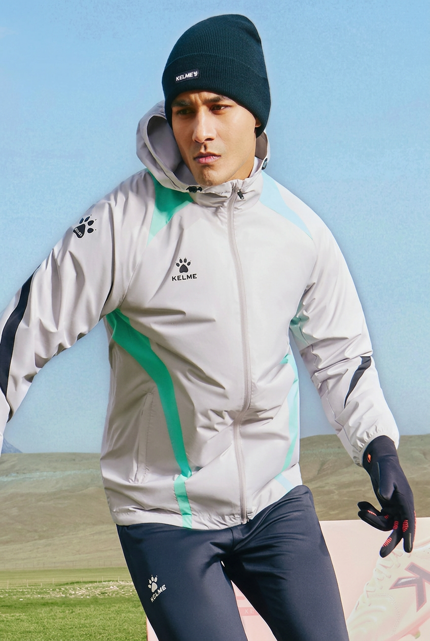 Model wearing a light gray hooded sports jacket outdoors